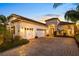 Elegant home showcasing a tile roof, white exterior, three-car garage, and beautifully landscaped front yard at 15520 Castle Park Ter, Lakewood Ranch, FL 34202