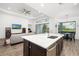 Open-concept kitchen features a large island, stainless steel appliances, and views of the living area and golf course at 15520 Castle Park Ter, Lakewood Ranch, FL 34202