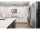 Bright kitchen showcasing white cabinetry, stainless steel appliances, mosaic backsplash, quartz countertops, and dark island at 15520 Castle Park Ter, Lakewood Ranch, FL 34202