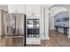 Stainless steel refrigerator and double oven in kitchen, leading to the formal dining room at 15520 Castle Park Ter, Lakewood Ranch, FL 34202