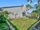 A backyard space features a well-maintained lawn, landscaping, and a glimpse of the side and rear of the home at 1705 Wharf Rd, Sarasota, FL 34231