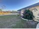 Manicured backyard with lake views and blooming vines on side of house at 1842 Country Meadows Ct, Sarasota, FL 34235