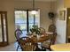 Bright dining area with a wooden table, chairs, and sliding glass doors overlooking a serene pond view at 1842 Country Meadows Ct, Sarasota, FL 34235