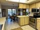 Functional kitchen featuring stainless steel appliances, wooden cabinets, and an adjacent dining area with pond views at 1842 Country Meadows Ct, Sarasota, FL 34235