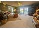 Spacious living room with leather sofas, ceiling fan, and sliding glass doors with lake views at 1842 Country Meadows Ct, Sarasota, FL 34235