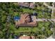 Expansive aerial view of tile roofed home, pool, lush landscaping, and circular brick driveway at 19424 Ganton Ave, Lakewood Ranch, FL 34202