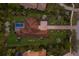 Aerial view of a luxurious property featuring a tiled roof, well-manicured lawns, a pool, and tropical landscaping at 19424 Ganton Ave, Lakewood Ranch, FL 34202