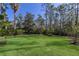 Spacious backyard featuring a lush lawn, black metal fence, and mature trees for privacy and enjoyment at 19424 Ganton Ave, Lakewood Ranch, FL 34202