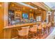 Elegant bar area featuring wooden accents, comfortable seating, and a fully stocked counter at 19424 Ganton Ave, Lakewood Ranch, FL 34202