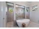 Bright bathroom featuring a soaking tub, glass shower with a rainfall showerhead and dual vanity at 19424 Ganton Ave, Lakewood Ranch, FL 34202