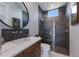 Modern bathroom with a wood vanity, white countertops, and a glass-enclosed shower with mosaic flooring at 19424 Ganton Ave, Lakewood Ranch, FL 34202