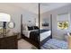 Stylized bedroom with a four-poster bed, dark wood furniture, and blue accents at 19424 Ganton Ave, Lakewood Ranch, FL 34202