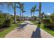 Grand view of a driveway lined with palm trees leading to an elegant home at 19424 Ganton Ave, Lakewood Ranch, FL 34202