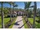 Stately white exterior elevation featuring manicured landscaping and a paver driveway lined with tall palms at 19424 Ganton Ave, Lakewood Ranch, FL 34202