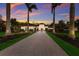 Elegant estate home featuring a paver driveway, lush landscaping, and a warm sunset backdrop at 19424 Ganton Ave, Lakewood Ranch, FL 34202