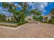 Image features a luxurious residence with lush landscaping, a circular driveway, and meticulously maintained grounds at 19424 Ganton Ave, Lakewood Ranch, FL 34202