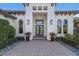 Welcoming front entrance featuring decorative planters and a meticulously paved walkway leading to a stylish home at 19424 Ganton Ave, Lakewood Ranch, FL 34202