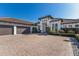 Beautiful home featuring a large paver driveway, a three-car garage, and meticulously maintained landscaping at 19424 Ganton Ave, Lakewood Ranch, FL 34202