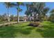 Beautifully landscaped front yard with a well-manicured lawn and palm trees framing a luxurious home at 19424 Ganton Ave, Lakewood Ranch, FL 34202