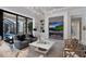 A modern living room with a fireplace, built-in shelving, and views of the backyard pool at 19424 Ganton Ave, Lakewood Ranch, FL 34202