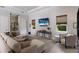 Inviting living room features a cozy sectional, a wine rack, and views of the serene backyard at 19424 Ganton Ave, Lakewood Ranch, FL 34202