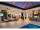 Open-concept indoor/outdoor space with kitchen, pool table, and living area that opens to the pool at 19424 Ganton Ave, Lakewood Ranch, FL 34202
