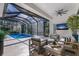Relaxing screened-in patio with comfortable seating, overlooks the sparkling pool and lush landscaping at 19424 Ganton Ave, Lakewood Ranch, FL 34202