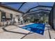 Beautiful outdoor pool area with outdoor kitchen, bar seating, and serene backyard views at 19424 Ganton Ave, Lakewood Ranch, FL 34202