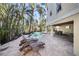 Outdoor backyard featuring a sparkling private pool, stone pavers, chaise lounge chairs, and covered seating area at 204 66Th Street, Holmes Beach, FL 34217