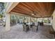Covered outdoor living space featuring ceiling fans, stone pavers, and dining next to the sparkling private pool at 204 66Th Street, Holmes Beach, FL 34217