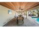 Outdoor entertaining area features a beautiful wood ceiling with ceiling fans and a private pool in the background at 204 66Th Street, Holmes Beach, FL 34217