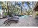 Private outdoor pool is surrounded by lush tropical foliage with stone pavers and chaise lounge chairs at 204 66Th Street, Holmes Beach, FL 34217