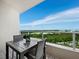 Outdoor balcony with table and seating overlooking scenic views of the water and greenery at 3010 Grand Bay Blvd # 482, Longboat Key, FL 34228
