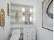 Modern powder room boasts striped walls, a sleek vanity, and stylish gold feather decorations at 3010 Grand Bay Blvd # 482, Longboat Key, FL 34228