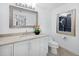Cozy bathroom featuring a vanity, toilet, and decoratively framed mirror with lighting at 3010 Grand Bay Blvd # 482, Longboat Key, FL 34228