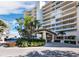 Luxury condominium exterior with lush landscaping, covered entrance, and circular driveway at 3010 Grand Bay Blvd # 482, Longboat Key, FL 34228