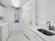 Bright laundry room featuring modern washer and dryer, white cabinets, and sink with elegant countertops at 3010 Grand Bay Blvd # 482, Longboat Key, FL 34228