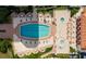 An aerial view of a large pool with ample lounge seating and tables on a sunny day at 3010 Grand Bay Blvd # 482, Longboat Key, FL 34228