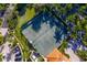 Aerial view of a well-maintained tennis court surrounded by lush landscaping and some buildings in the community at 3010 Grand Bay Blvd # 482, Longboat Key, FL 34228