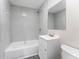 Bathroom featuring bathtub with gray tile surround, updated vanity and gray wood-look flooring at 3457 50Th N Ave, St Petersburg, FL 33714