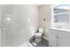 Bathroom featuring a white vanity, toilet, gray wood-look flooring, and a shower and tub with gray tile surround at 3457 50Th N Ave, St Petersburg, FL 33714