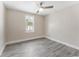Neutral bedroom has a ceiling fan, large window and gray wood-look flooring at 3457 50Th N Ave, St Petersburg, FL 33714