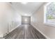 Long bonus room features gray wood-look flooring and plenty of natural light from the windows at 3457 50Th N Ave, St Petersburg, FL 33714