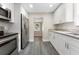 Modern kitchen with stainless steel appliances, white cabinets, and gray laminate flooring at 3457 50Th N Ave, St Petersburg, FL 33714