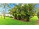 Lush backyard featuring a covered patio, mature landscaping, and a well-maintained lawn at 3839 Autumn Fern Ter, Sarasota, FL 34243