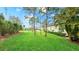 Expansive backyard features a lush green lawn, mature trees, and meticulously maintained landscaping at 3839 Autumn Fern Ter, Sarasota, FL 34243