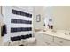 This bathroom features a vanity with a white sink, striped shower curtain, and toilet at 3839 Autumn Fern Ter, Sarasota, FL 34243