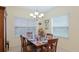 A bright dining room features a wood table set for six under a chandelier at 3839 Autumn Fern Ter, Sarasota, FL 34243