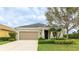 Charming single-story home featuring a well-manicured lawn, an attached two-car garage, and verdant landscaping at 3839 Autumn Fern Ter, Sarasota, FL 34243