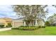 Attractive single-level home boasting lush green landscaping, a large tree, and an attached two-car garage at 3839 Autumn Fern Ter, Sarasota, FL 34243